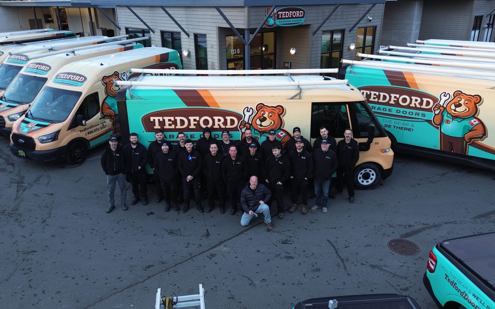 The Tedford Garage Doors crew outside the Victoria shop on Vanalman Avenue, with the fleet of Tedford service vans