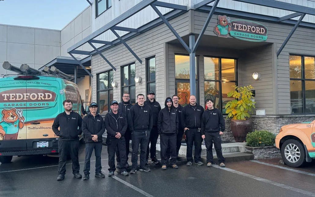 The Tedford Garage Doors Victoria crew outside the shop on Vanalman Avenue, with Tedford service vans on either side