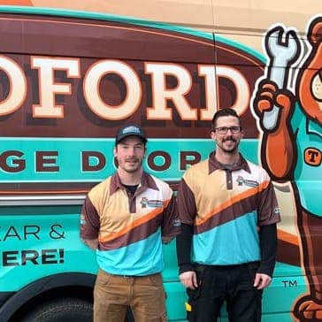 Two Tedford technicians beside a Tedford van with the bear mascot